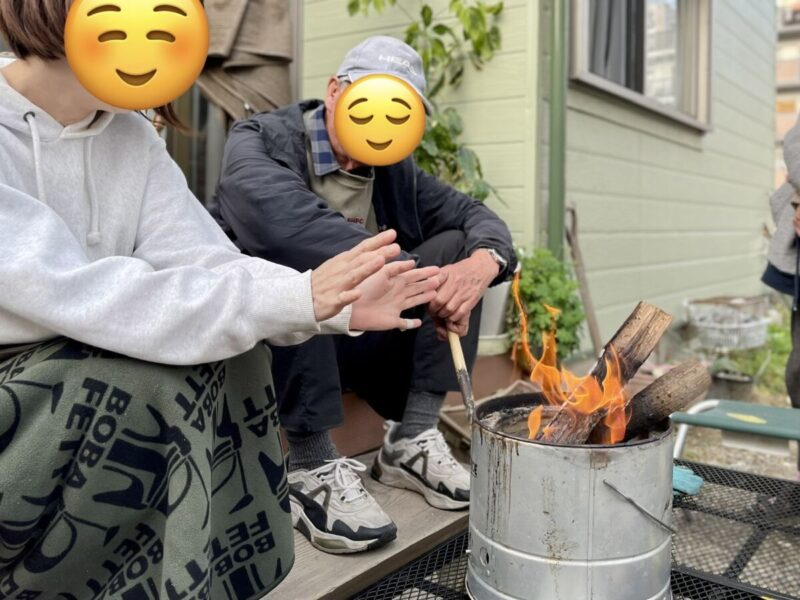 尾上製作所の七輪を焚き火台として活用し庭で暖をとる様子